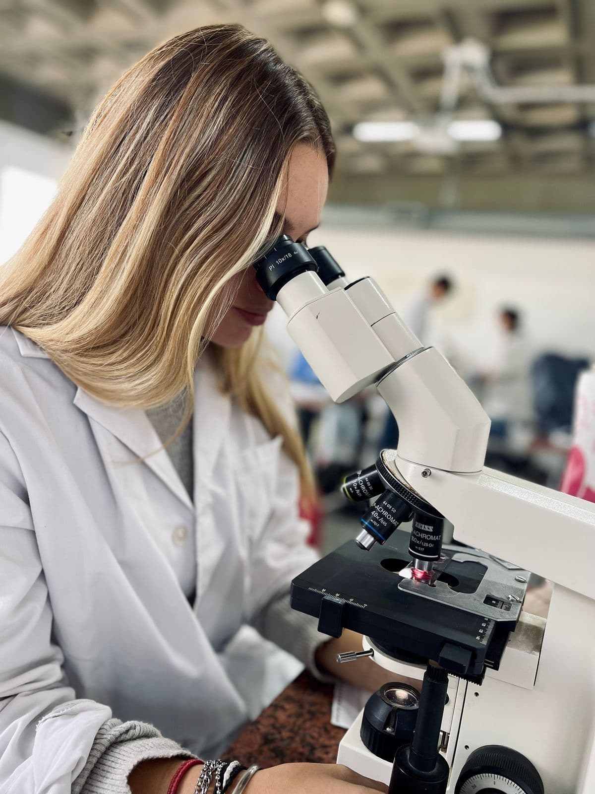 Martina Pilar Toro observando por un microscopio en el laboratorio